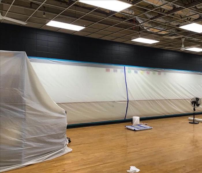 Containment covering walls in a large room of a business.