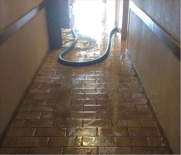 green water hose in a wet floor